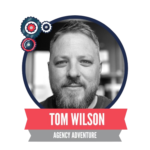 A black and white portrait of a man with a beard in a circular frame, with decorative gears and labeled "Tom Wilson, Agency Adventure" on a red ribbon below.