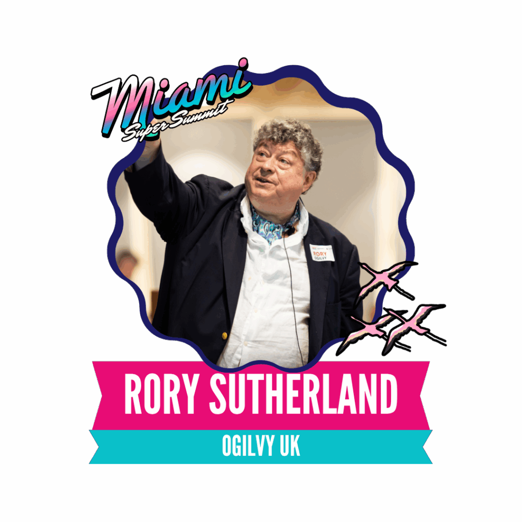 A man is speaking at a presentation, wearing a blazer and a badge, with "Rory Sutherland, Ogilvy UK" displayed below. The background features a stylized Miami-themed design.